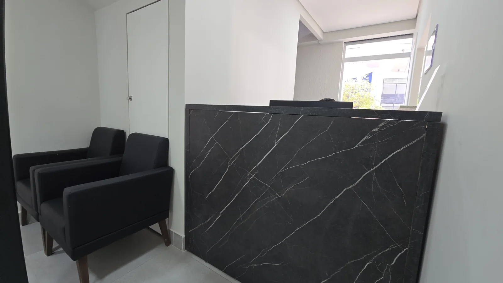 Balcão de recepção e poltronas da unidade