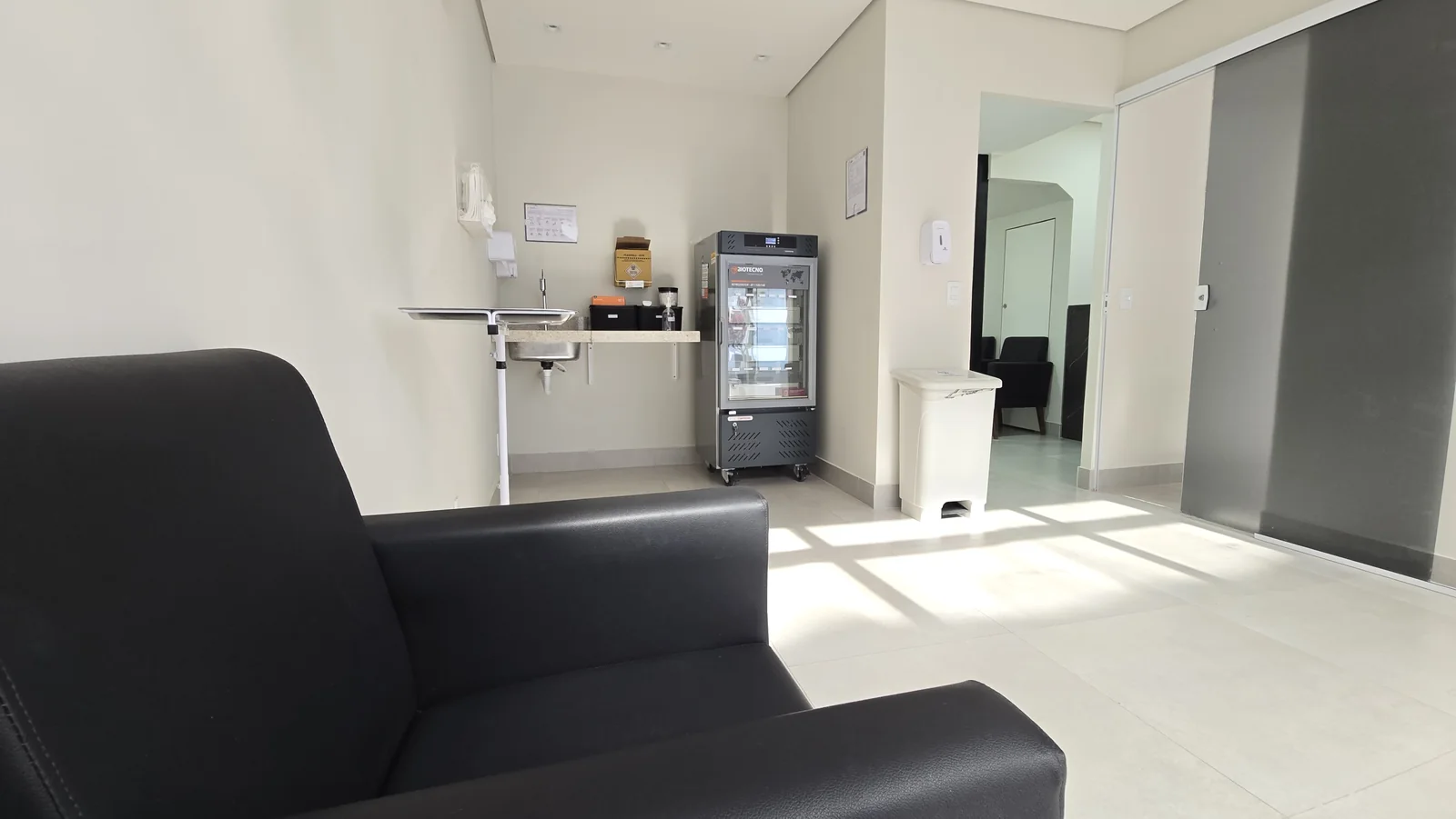 Sala com poltrona de atendimento, bancada e refrigerador